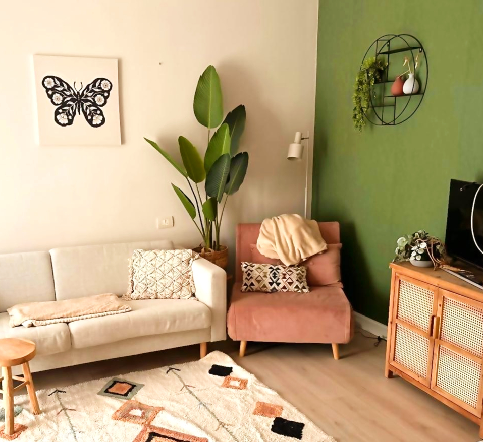 Woonkamer met groene muur en witte bank