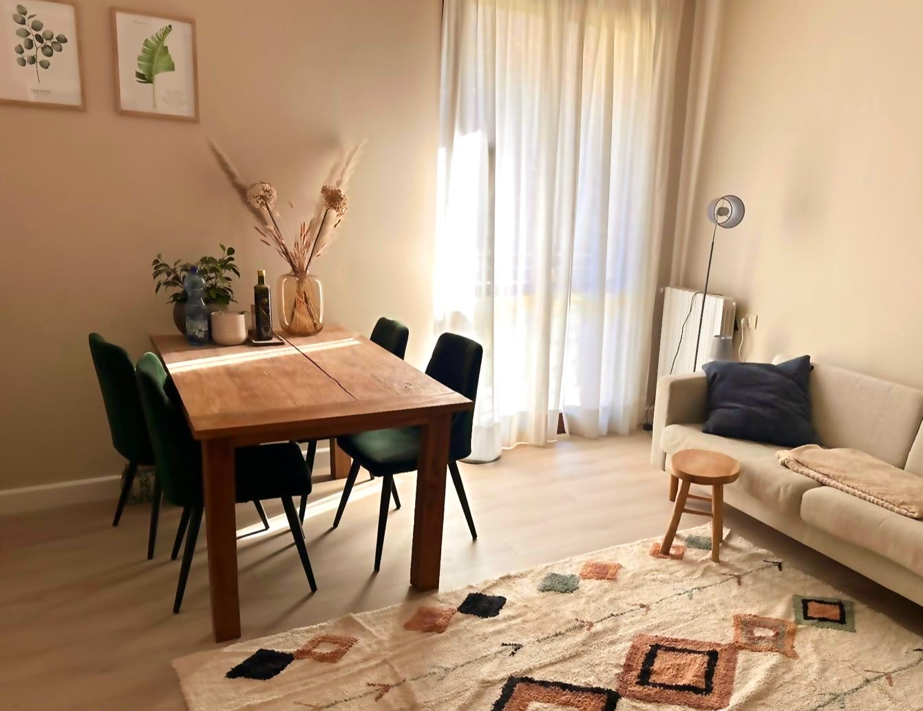 Eetkamer met houten tafel en groene stoelen bij daglicht