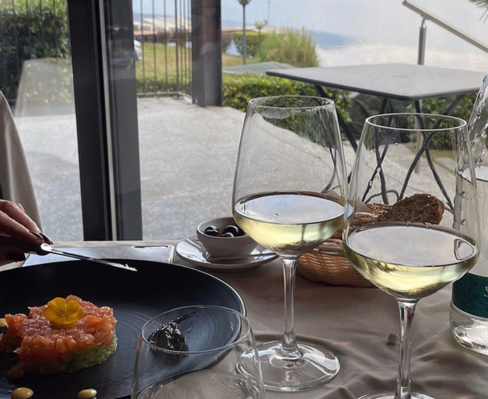 Verfijnd diner met witte wijn en uitzicht op het meer